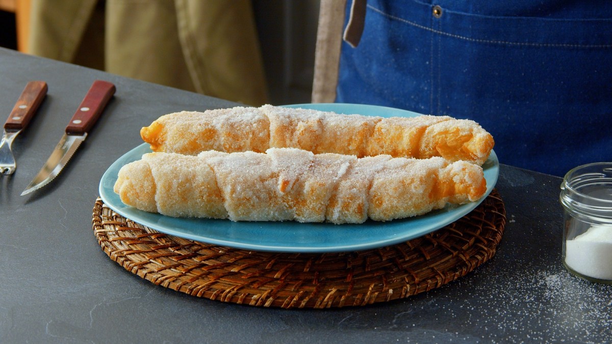 Zwei Milchreis-Churros auf einem Teller.