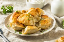 Pierogi mit Kohl-Kartoffel-Füllung auf einem Teller.