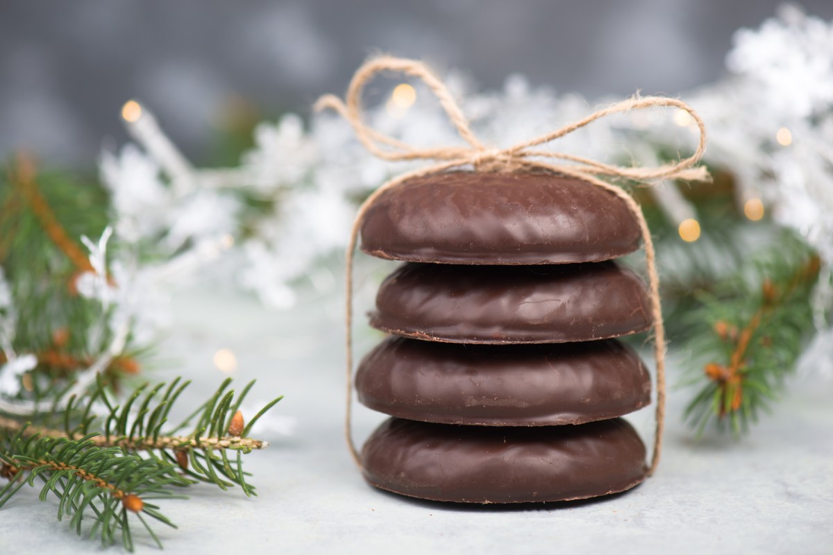 Rezept fÃ¼r Lebkuchen: 4 NÃ¼rnberger Lebkuchen gestapelt und mit einem Band zusammengebunden, dahinter Weihnachtsdeko.