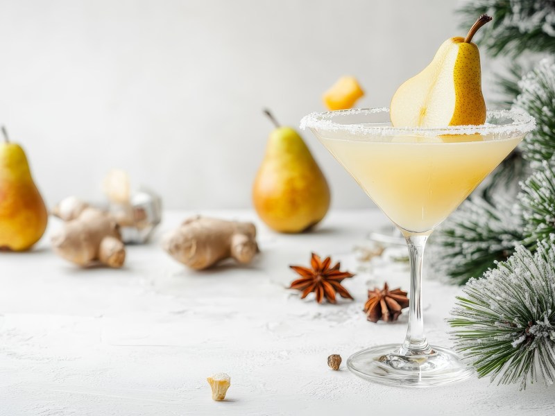 Ein Glas Birnen-Martini mit Birnen im Hintergrund und winterlichen GewÃ¼rzen