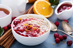 Eine Schüssel Cranberry-Porridge mit etwas Orange.