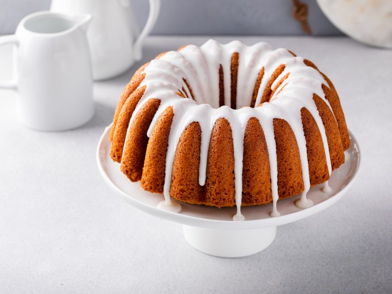 Ein Eierlikörkuchen mit Guss auf einem Kuchentablett.