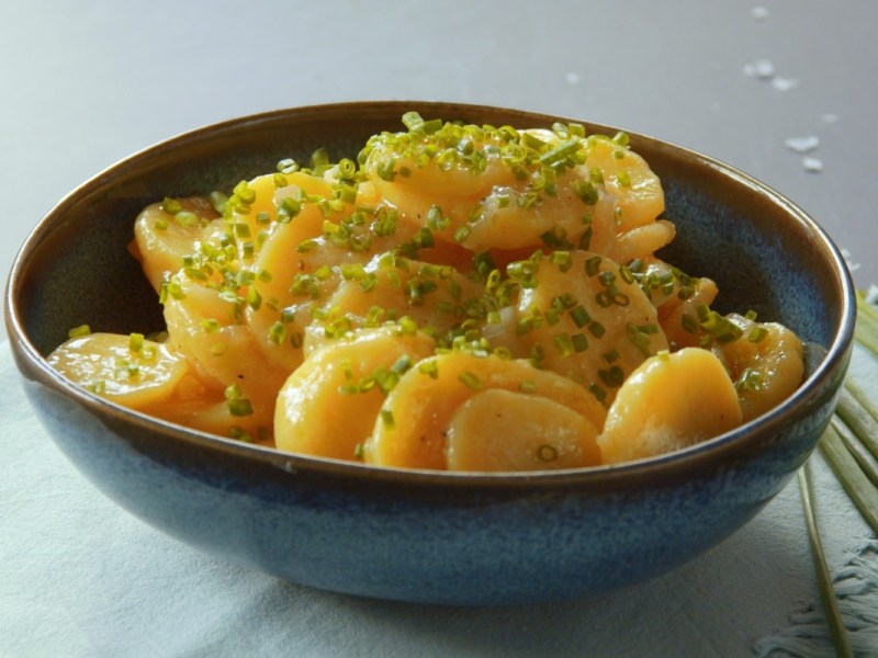 Eine Schale Kartoffelsalat mit Essig und Öl.