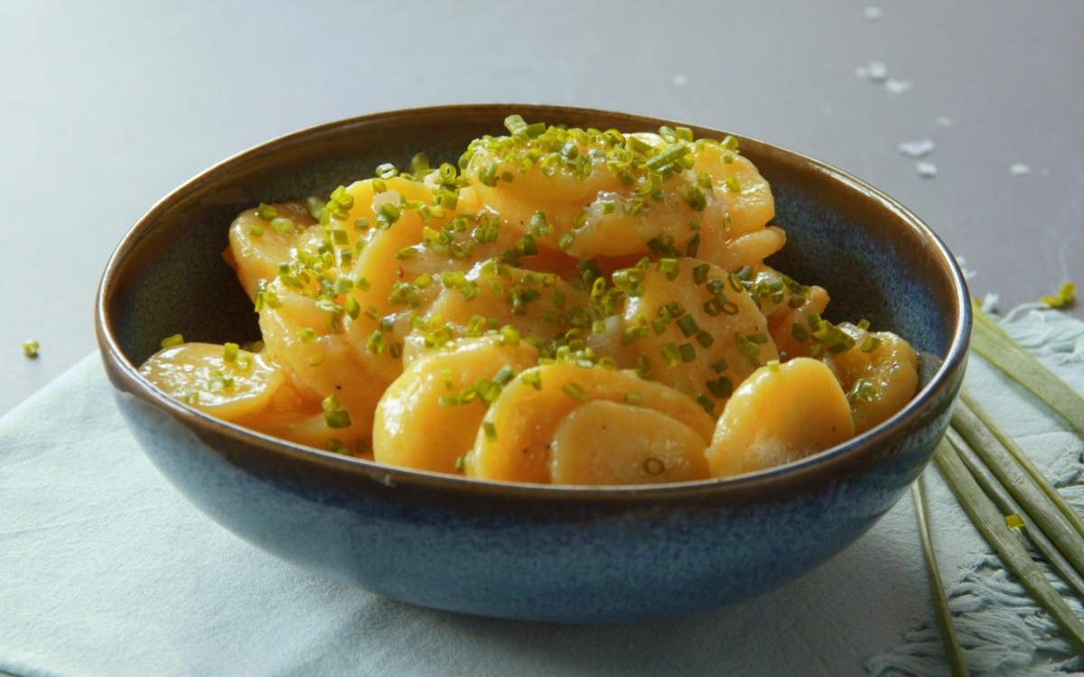 Eine Schale Kartoffelsalat mit Essig und Öl.