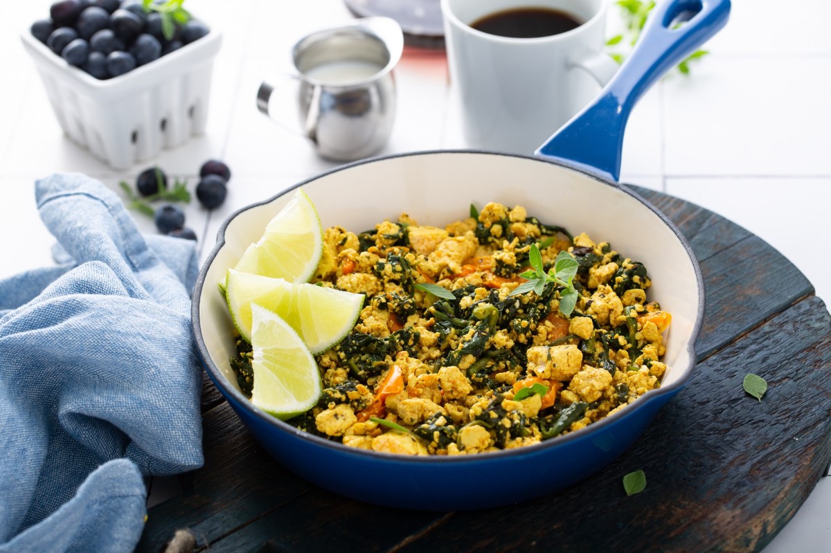 Rührtofu in einer blauen Pfanne, garniert mit Zitrone.