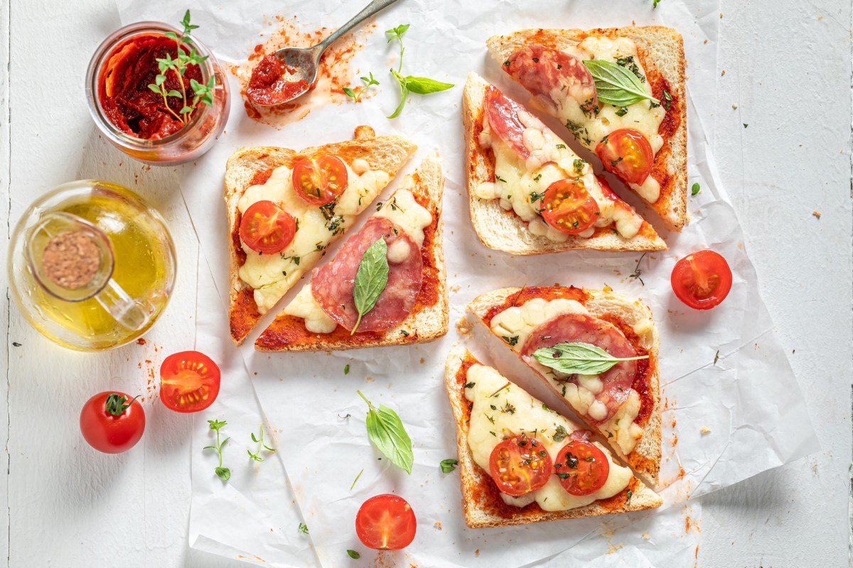 Ãœberbackene Mozzarella-Toasts, umgeben von Zutaten.