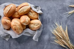 Brötchen ohne Kneten: Ein Korb Brötchen, daneben Weizenähren