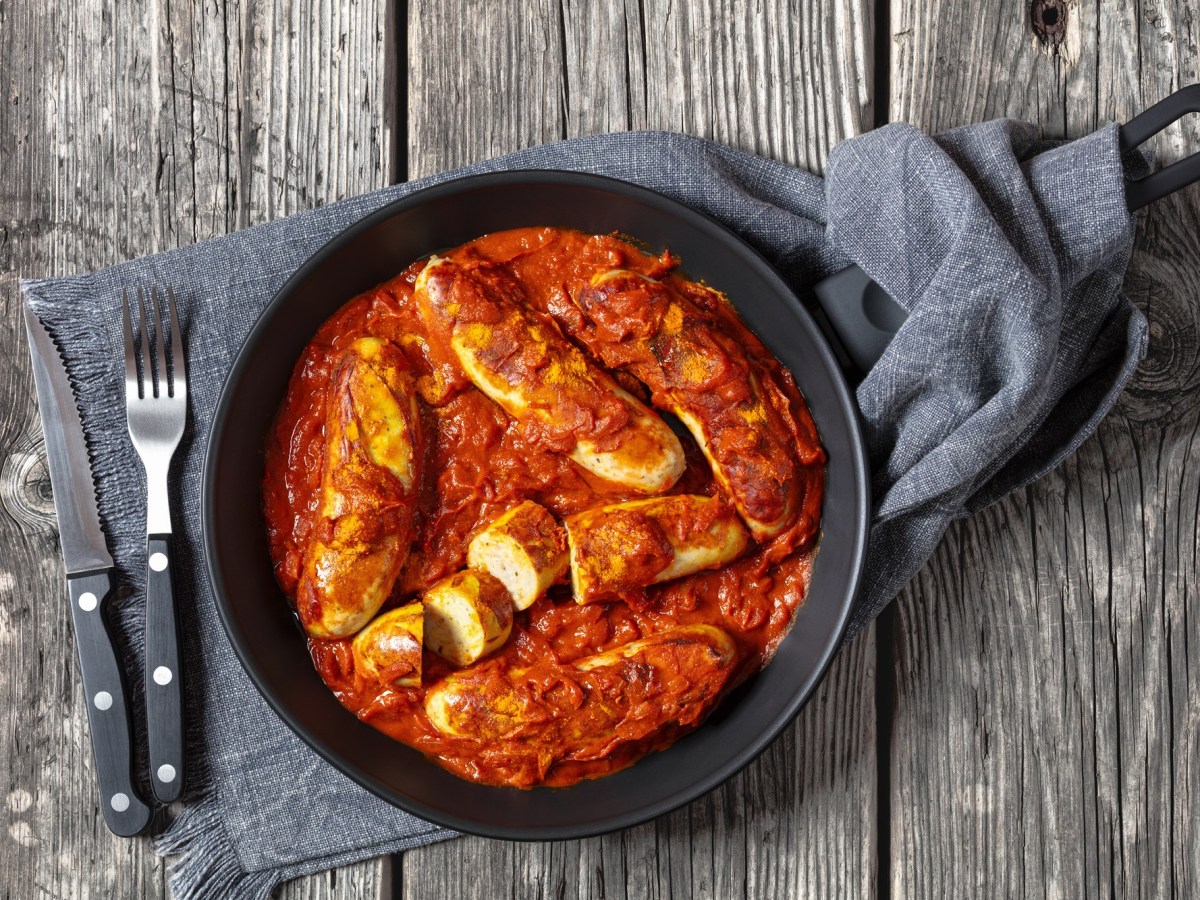 Currywurst-Pfanne mit Besteck daneben