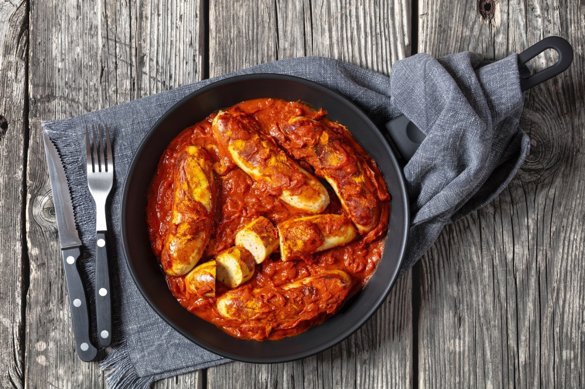 Currywurst-Pfanne mit Besteck daneben