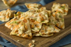 Kichererbsen-Chips angerichtet auf einem Holzbrett.