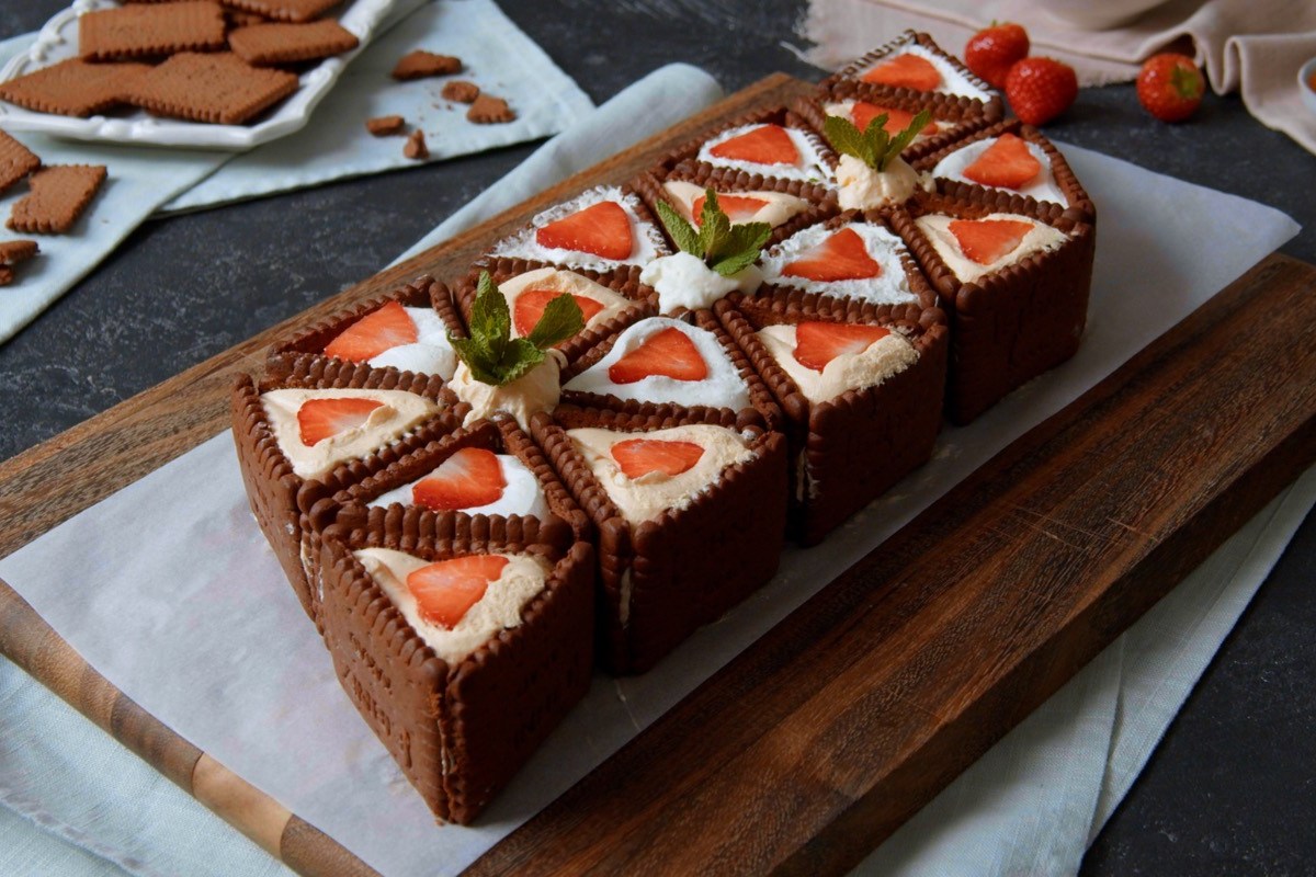 No-bake-Kuchen-mit-Butterkeksen, angerichtet auf einem Backpapier und Brett.