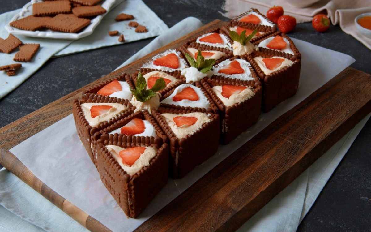 No-bake-Kuchen-mit-Butterkeksen, angerichtet auf einem Backpapier und Brett.