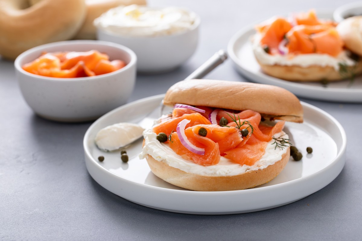 RÃ¤ucherlachs-Bagels mit Kapern und Dill auf mehreren Tellern.