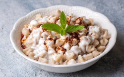 Türkische Manti mit Joghurtsoße auf einem Teller.