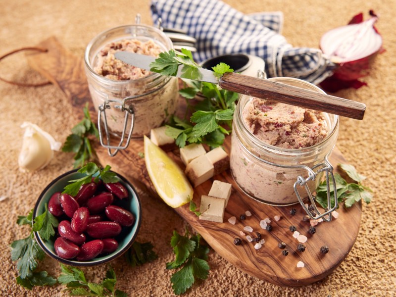 Zwei GlÃ¤ser mit veganer Leberwurst auf einem Tisch