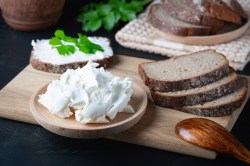 Quark selbst machen: Ein Teller mit selbstgemachtem Quark, daneben mehrere Brotscheiben.